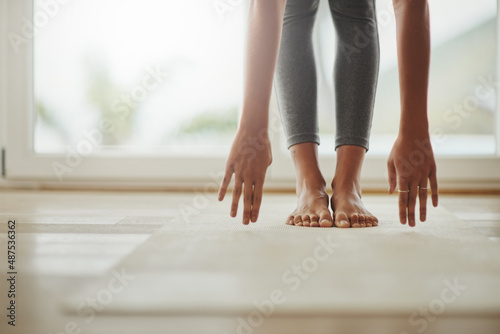 Yoga can always be modified to fit peoples needs. Cropped shot of a young woman practicing yoga at home. © Delmaine Donson/peopleimages.com
