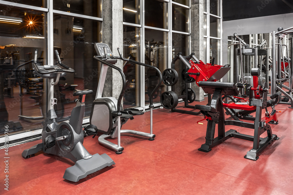 Various special equipment for physical training by the window in spacious, well lit, empty gym interior. Modern exercise machines. Sport, fitnes