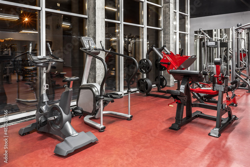 Various special equipment for physical training by the window in spacious, well lit, empty gym interior. Modern exercise machines. Sport, fitnes