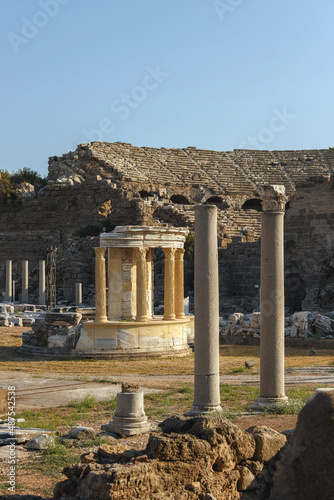 Temple of Fortune (Tyche Tapinagi) at commercial Agora, ancient theather in the background. Side (Turkey, Antalya region). Remains of the ancient city. History, art or religion history concept photo