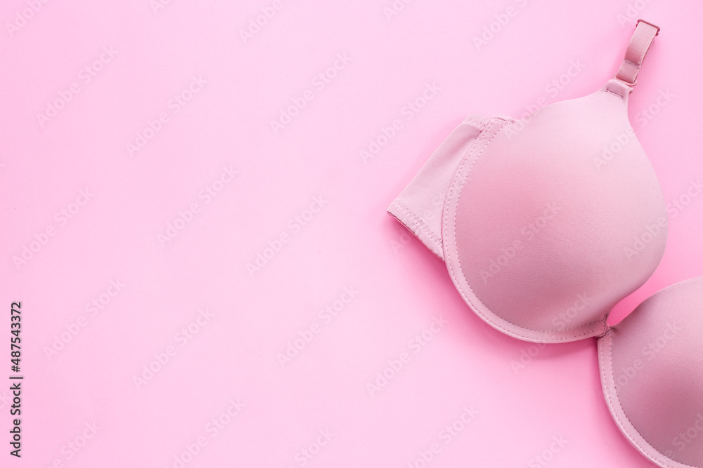 Breast cancer awareness concept with pink bra, top view