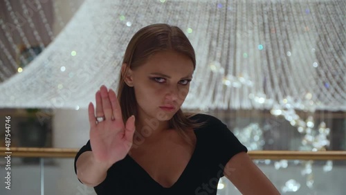 The woman shows gestures stop. European girl refuses. Caucasian girl looks with disgust. The woman shows antipathy. 