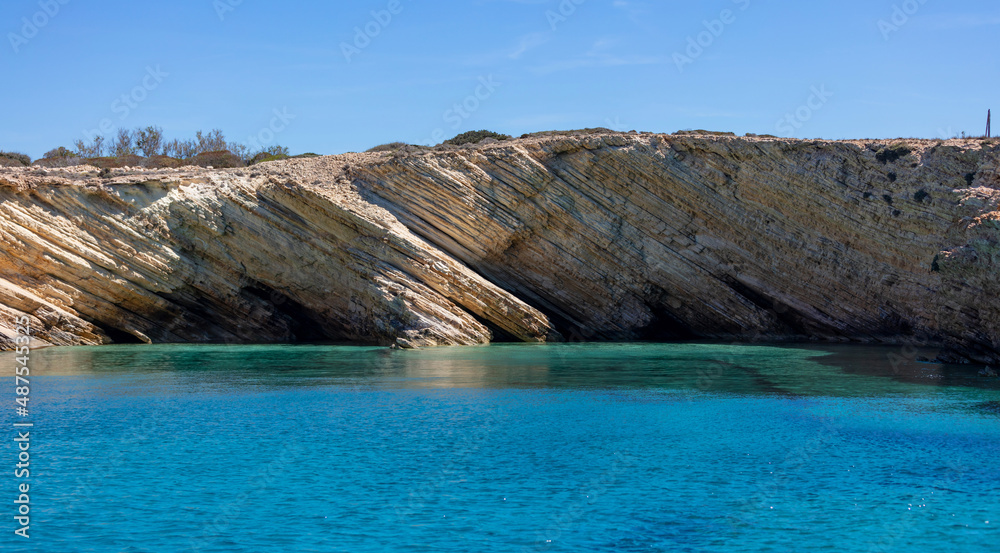 Koufonisi island, Cyclades, Greece. Xilombatis Cave, rocky formation, calm Aegean sea