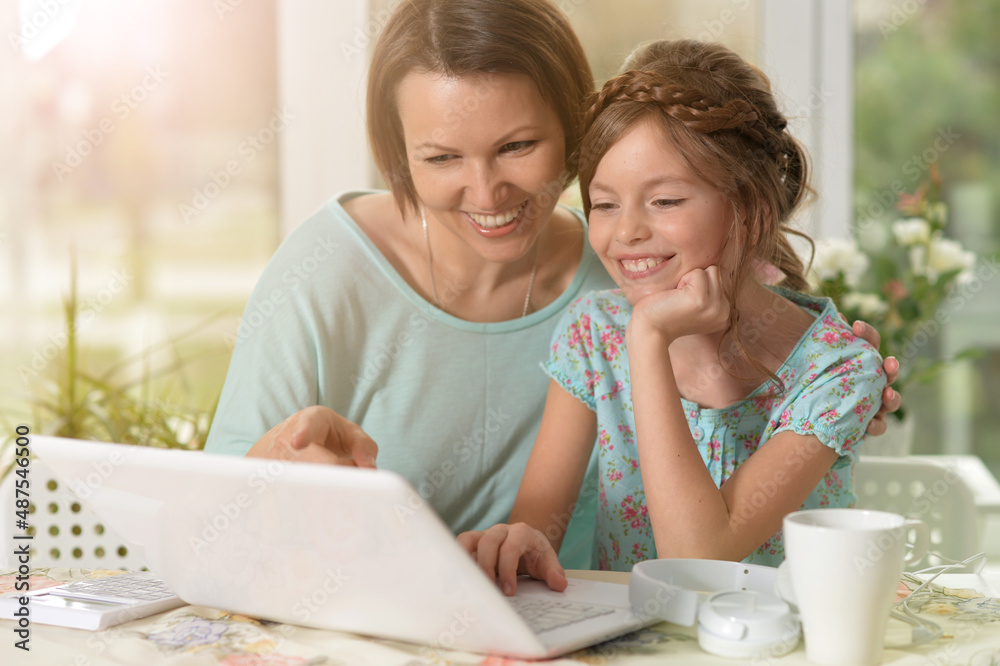 mother and daughter using laptop mother and daughter using laptop