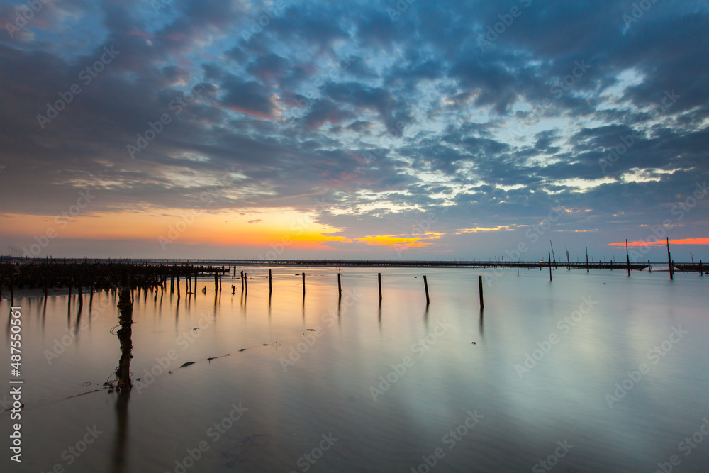Fototapeta premium Beautiful landscape of sea level reflect fantasy dramatic sunset sky in wetlands , the famous travel attractions in Changhua Binhai Industrial Zone, Taiwan. (彰濱)