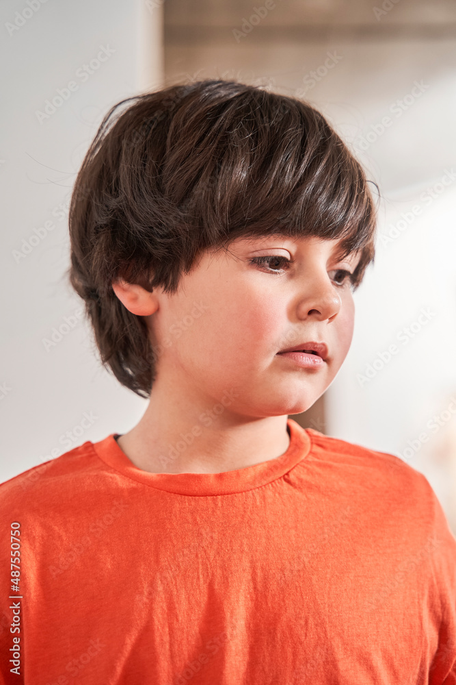 Caucasian brunette child boy looking away while standing at the art school room