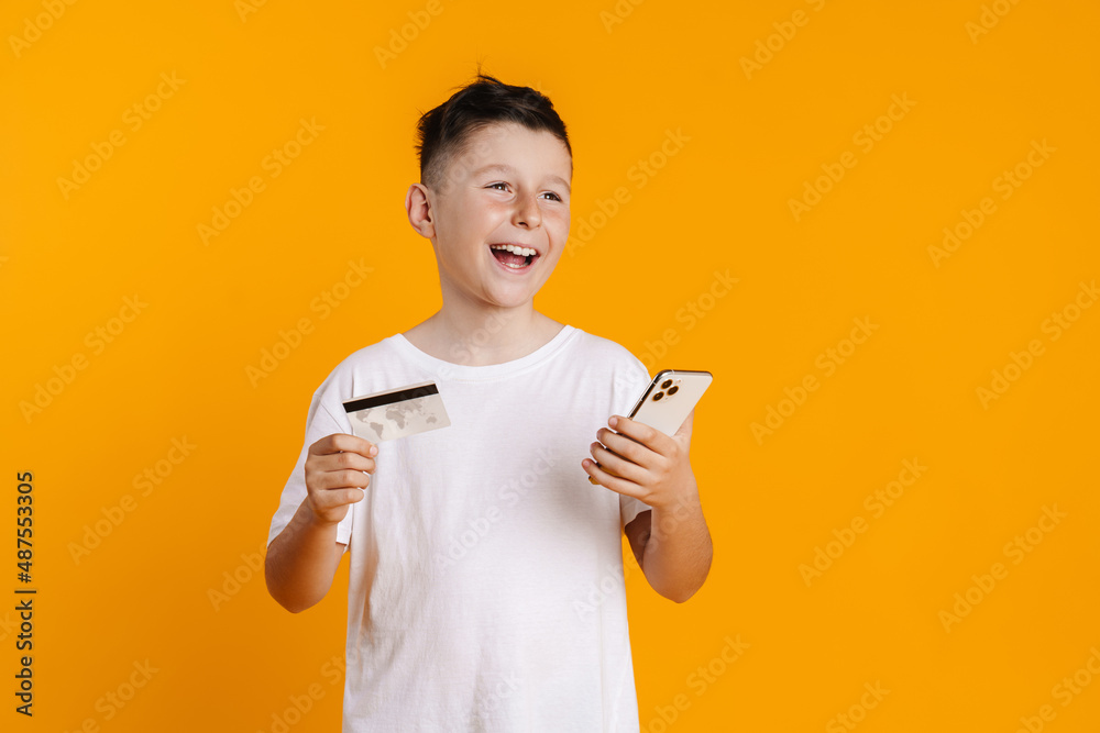 Brunette white boy posing with credit card and cellphone Brunette white boy posing with credit card and cellphone