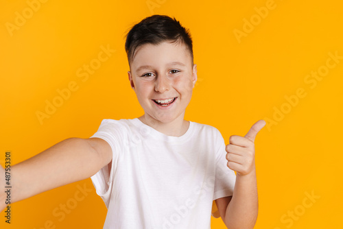 Brunette white boy taking selfie photo while showing thumb up