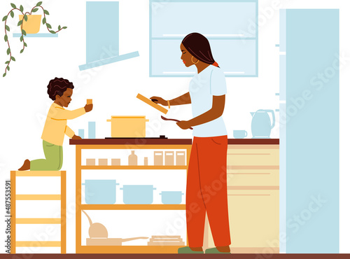 Mother cooking dinner with son. Child helping in food preparation