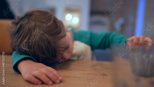 Bored little boy lying on floor at home child having nothing to do