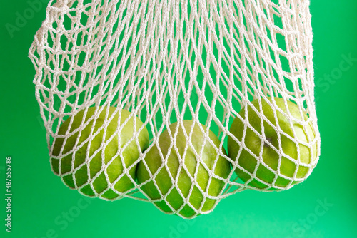 Fresh green apples in a mesh bag. Healthy food, eco-friendly packaging. Waste recycling. Zero  waste.
