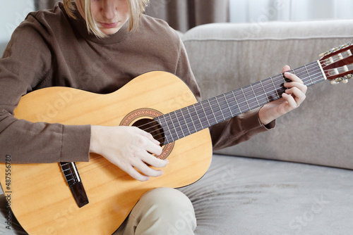 Handsome young guy hold acoustic instrumental guitar playing song