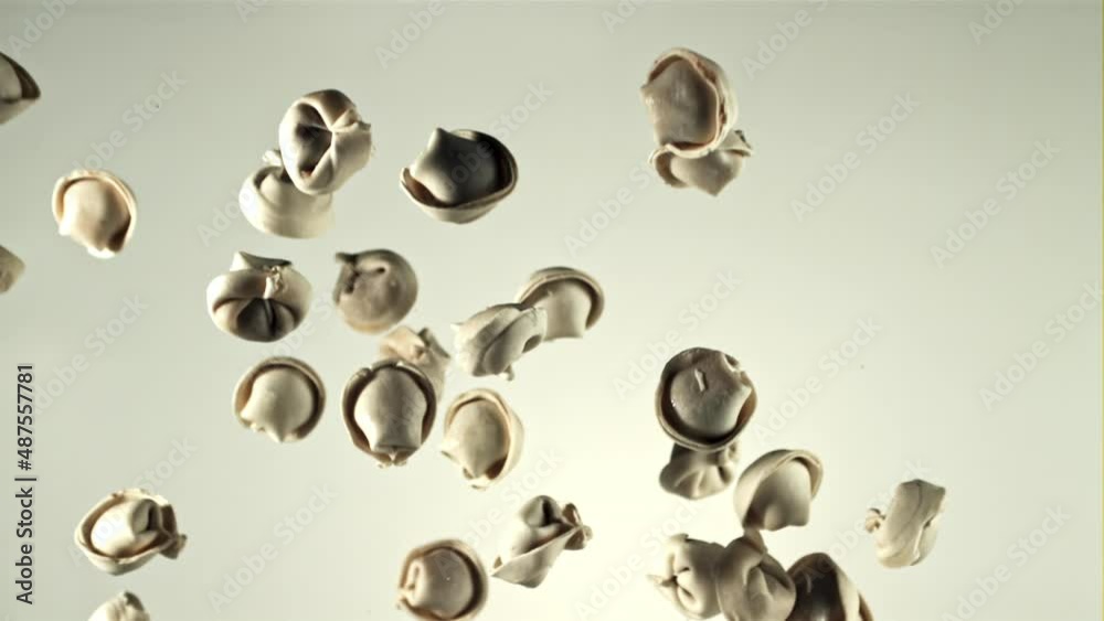 Dumplings raw fly up and fall down. On a white background. Filmed is slow motion 1000 fps. High quality FullHD footage Dumplings raw fly up and fall down. On a white background. Filmed is slow motion 1000 fps. High quality FullHD footage