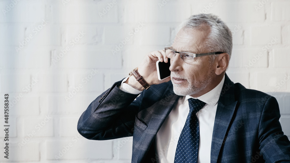 Businessman in formal wear talking on cellphone in office Businessman in formal wear talking on cellphone in office