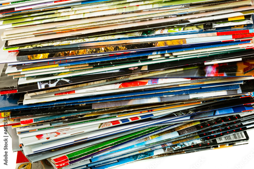 A messy pile of old, colorful magazines on light background.