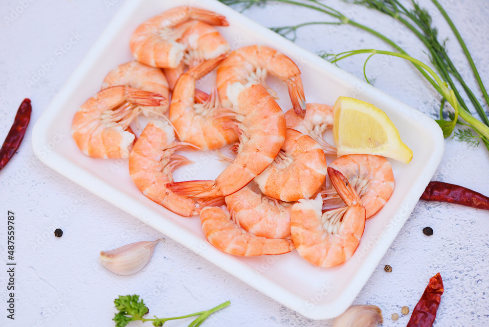 Fresh shrimps on on plate plastic tray with herbs and spices lemon chili on white background, boiled shrimp prawns cooked food in the seafood restaurant Fresh shrimps on on plate plastic tray with herbs and spices lemon chili on white background, boiled shrimp prawns cooked food in the seafood restaurant