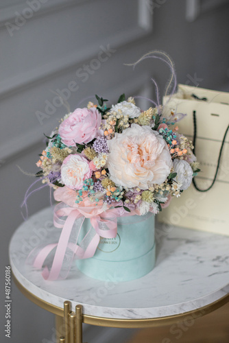 Beautiful spring flowers in box of tender peonies, roses and Gypsophila flowers. Preserved flowers for womens.