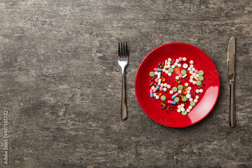 Many different weight loss pills and supplements as food on round plate. Pills served as a healthy meal. Drugs, pharmacy, medicine or medical healthycare concept photo