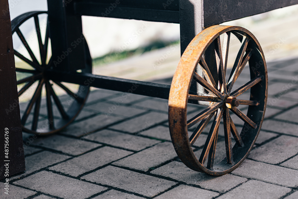 Cast iron spoked wheel from a large outdoor barbecue close-up