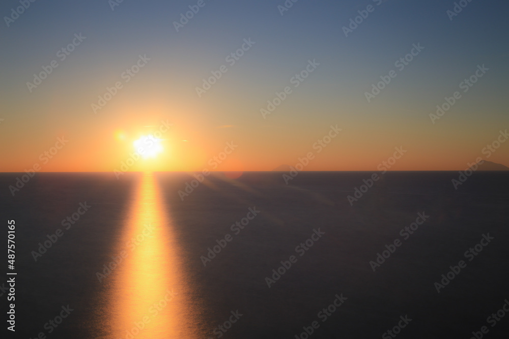 Fototapeta premium Sunset over the Mediterranean sea with clear sky. Sun over the water