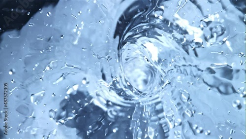 A whirlpool of water with air bubbles. Top view. Macro background.Filmed is slow motion 1000 fps. photo