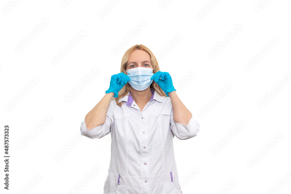 Cheerful young female doctor in mask and gloves looking at camera isolated on white