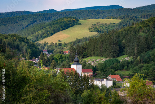 view of green countryside during summer village and church in valley