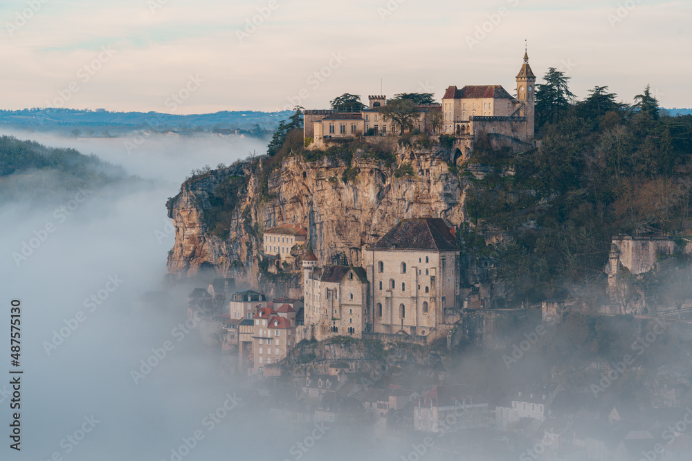 Rocamadour sunrise, Aerial view of the french village and castle on cliff in early morning with fogs in the Canyon of the Alzou - obrazy, fototapety, plakaty 
