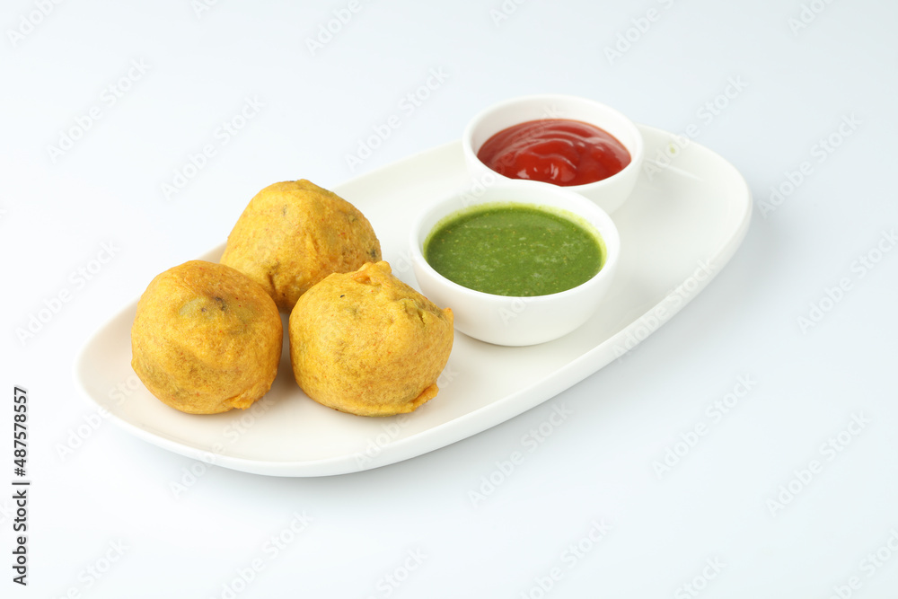 Indian snack aloo vada or bonda made from potato with coconut chutney. Indian snacks Aloo Bonda vada, pakoda, pakora.Paneer bonda indian snack, Served with tomato sauce placed Indian snack aloo vada or bonda made from potato with coconut chutney. Indian snacks Aloo Bonda vada, pakoda, pakora.Paneer bonda indian snack, Served with tomato sauce placed