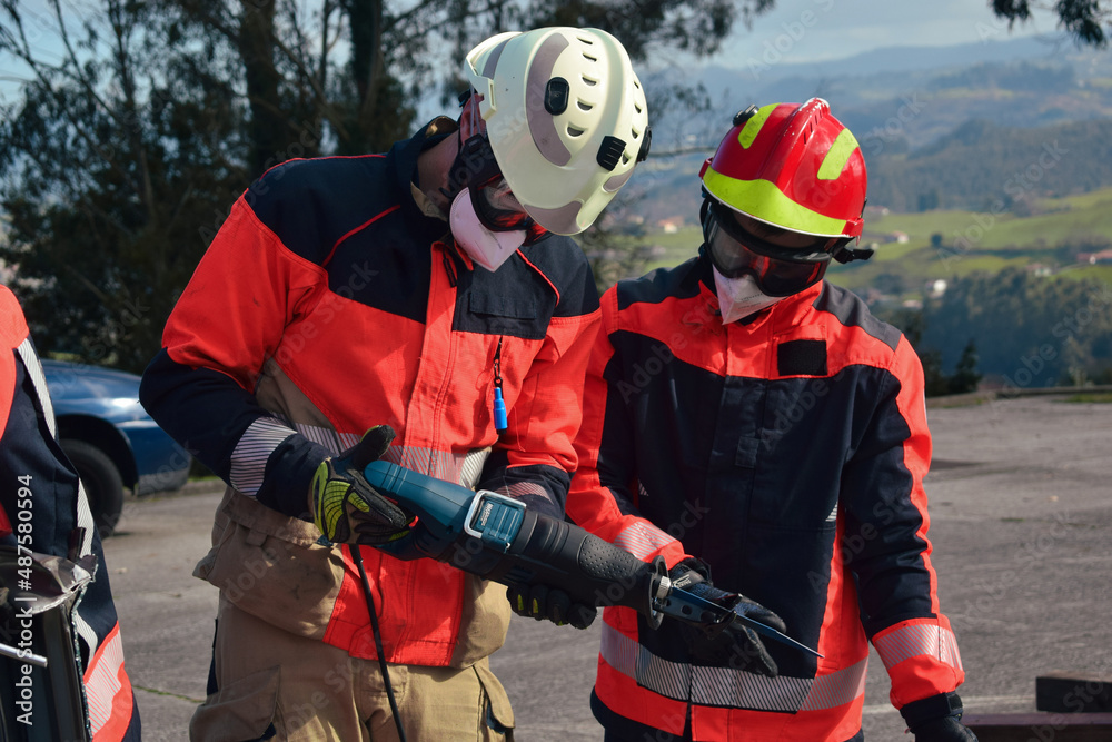 Obraz premium Firefighters looking at their tool before a rescue