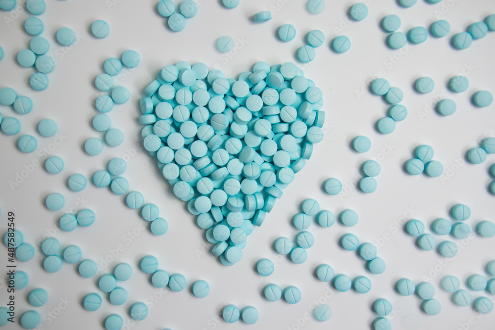 Obraz premium Heart made of blue pills isolated on white background 