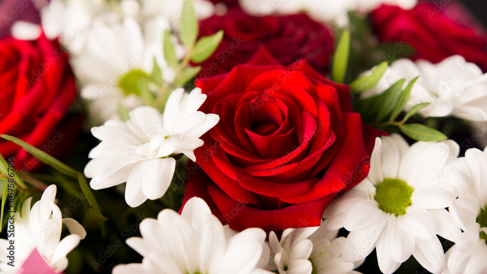 Fototapeta premium Closeup bouquet of red roses with with daisies.