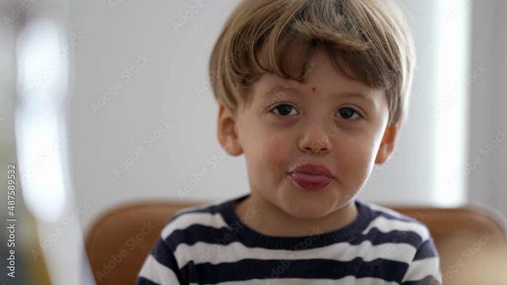 Cute little boy spitting to camera sticking tongue out being playful Cute little boy spitting to camera sticking tongue out being playful