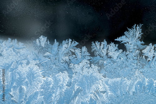 Frosty window glass, winter season, cold weather concept.  Macro view of frozen water crystalline structure, dark background with room for copy above.