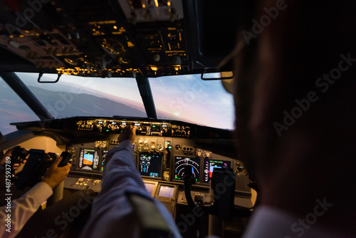 back view of professionals piloting airplane simulator in evening.
