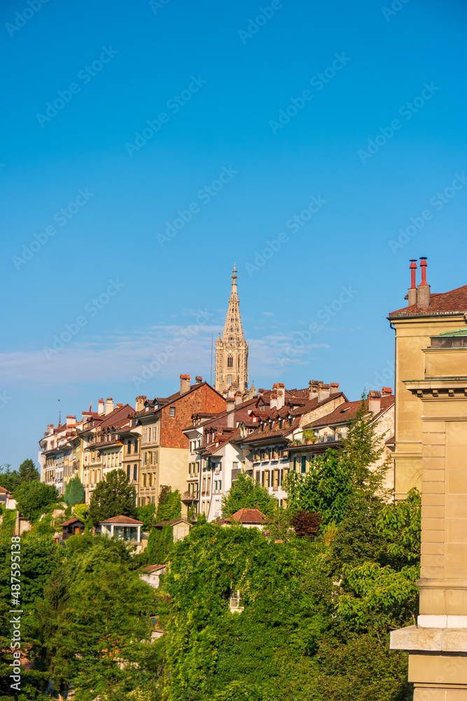 Cityscape with rooftops and tower of Bern Minster in the historic center of Bern, Switzerland.