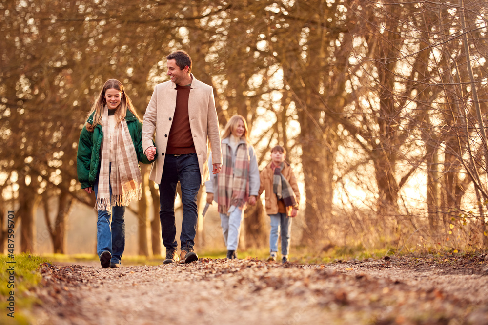 Family Holding Hands On Walk Through Autumn Countryside Together Family Holding Hands On Walk Through Autumn Countryside Together