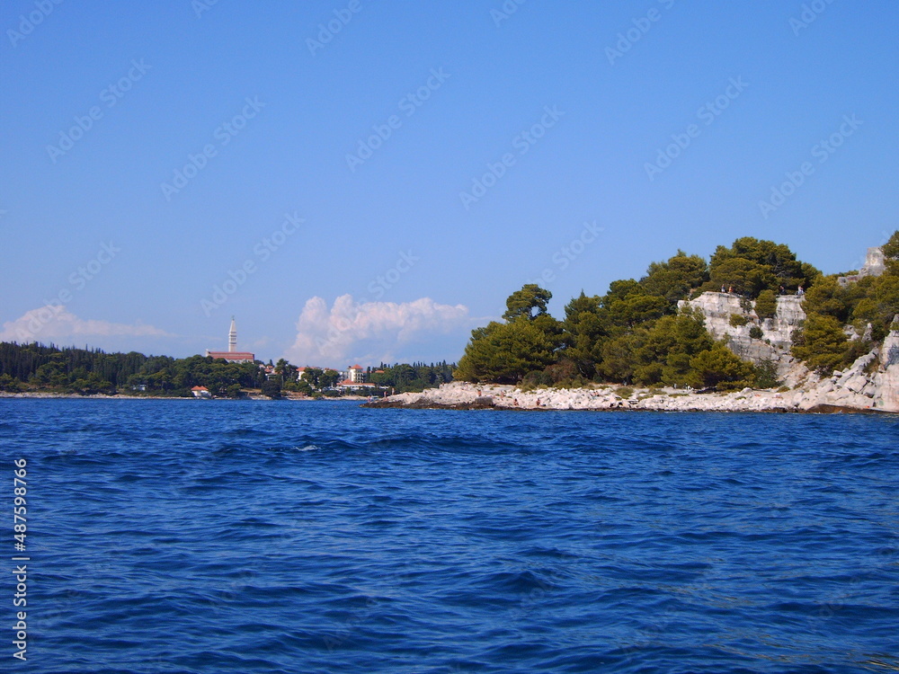 Obraz premium Küste in Kroatien mit Steinen, Meer und blauem Himmel am Strand, Blick nach Rovinj