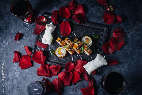 romance sushi dinner with hearts and wax figures in rose petals