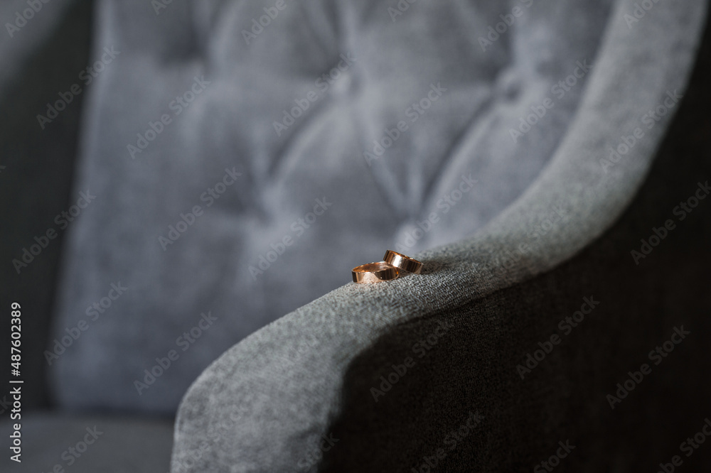 Obraz premium Wedding rings on the armrest of a velour armchair 3901.