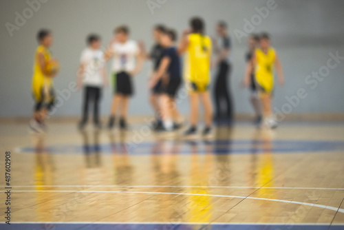 View of basketball court hall indoor venue with junior teenage school team playing in the background, basketball match game on arena stadium, team is blurred with copy space