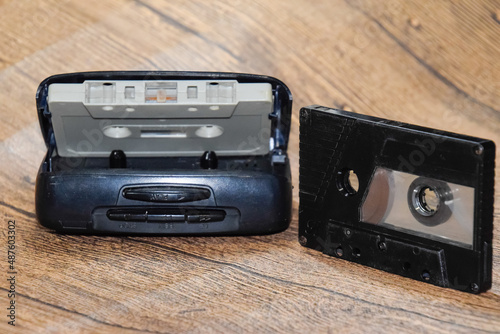 Retro audio cassettes next to a portable player to play compact cassettes.