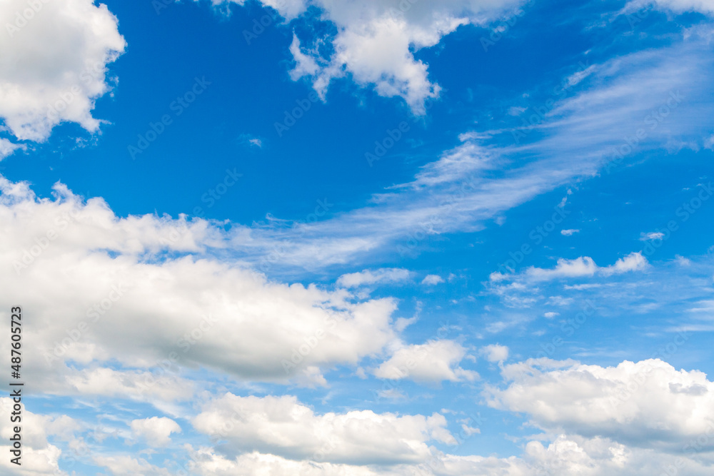 Obraz premium Bright blue sky with lots of white clouds. Beautiful summer sky as background.
