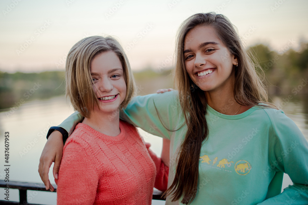 Two smiling girls. Two friends. Happy female students having fun together. Two young girls in the evening outside Two smiling girls. Two friends. Happy female students having fun together. Two young girls in the evening outside