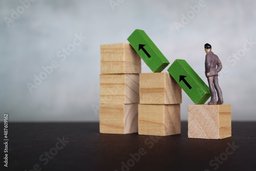 Growth, success and business concept. Miniature man looking at wooden step stair