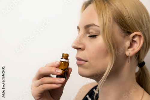 Relaxation, aromatherapy. Young girl sniffs essential oil.