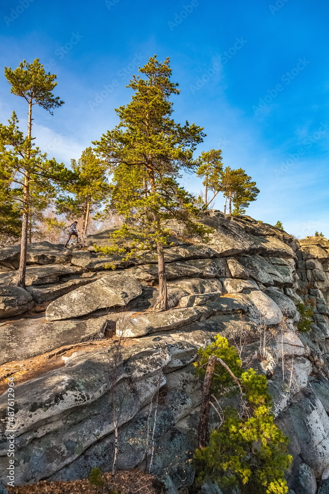 Autumn landscape with trees and rocks on top of a mountain against the sky