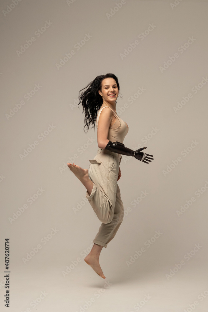 Woman with prosthetic robotic arm, bionic artificial hand jumping isolated  on beige background. Natural Skin Nature Makeup Fresh Spa Women's Cosmetic  Portrait. Beauty variety. Positive. Copy space Photos | Adobe Stock