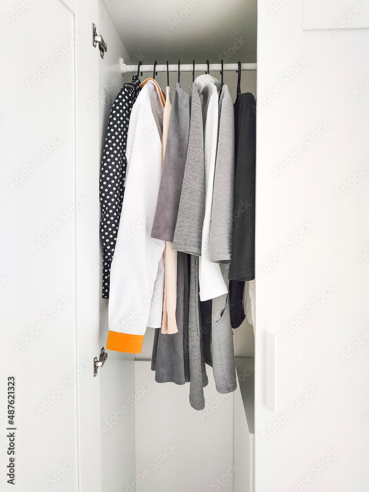 Wardrobe with basic clothes in room scandi interior. Neutral colors. Wardrobe with basic clothes in room scandi interior. Neutral colors.