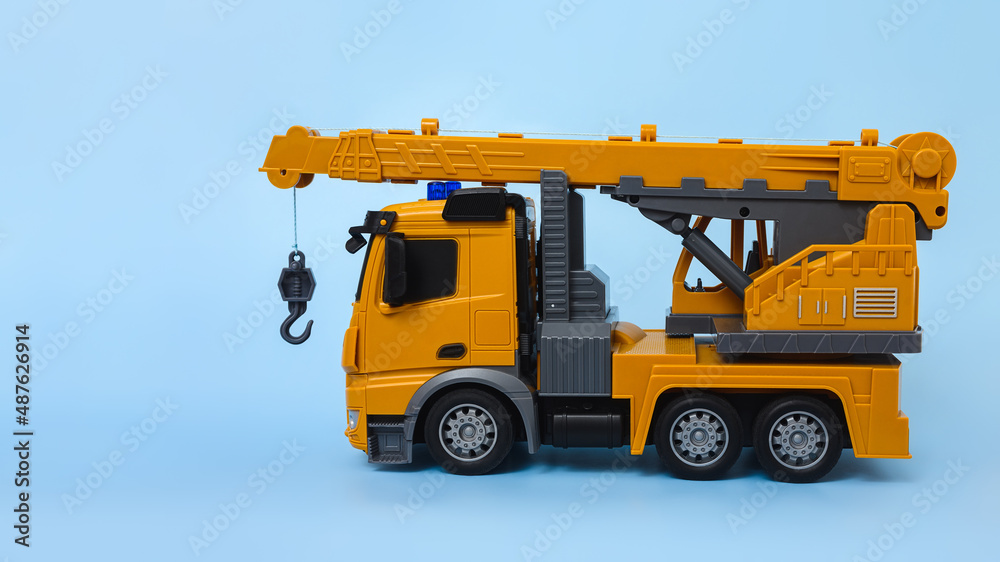 children's toy - car crane on a blue background side view